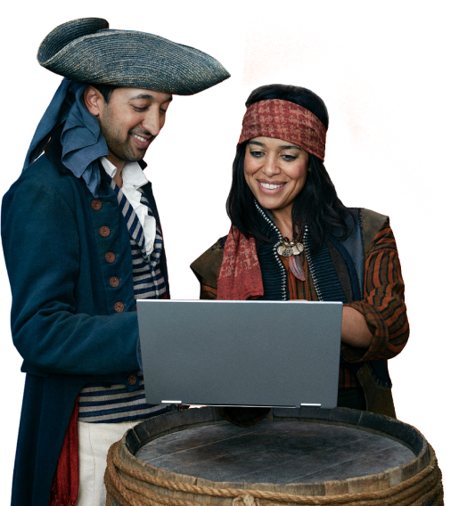 Two pirates looking at a laptop over a makeshift barrel of rum desk