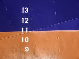 Markers on hull of commercial ship that indicate designated displacement, the ships weight when fully loaded