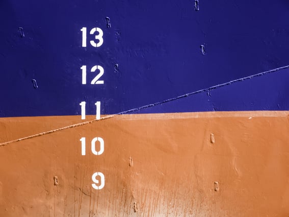 Markers on hull of commercial ship that indicate designated displacement, the ships weight when fully loaded